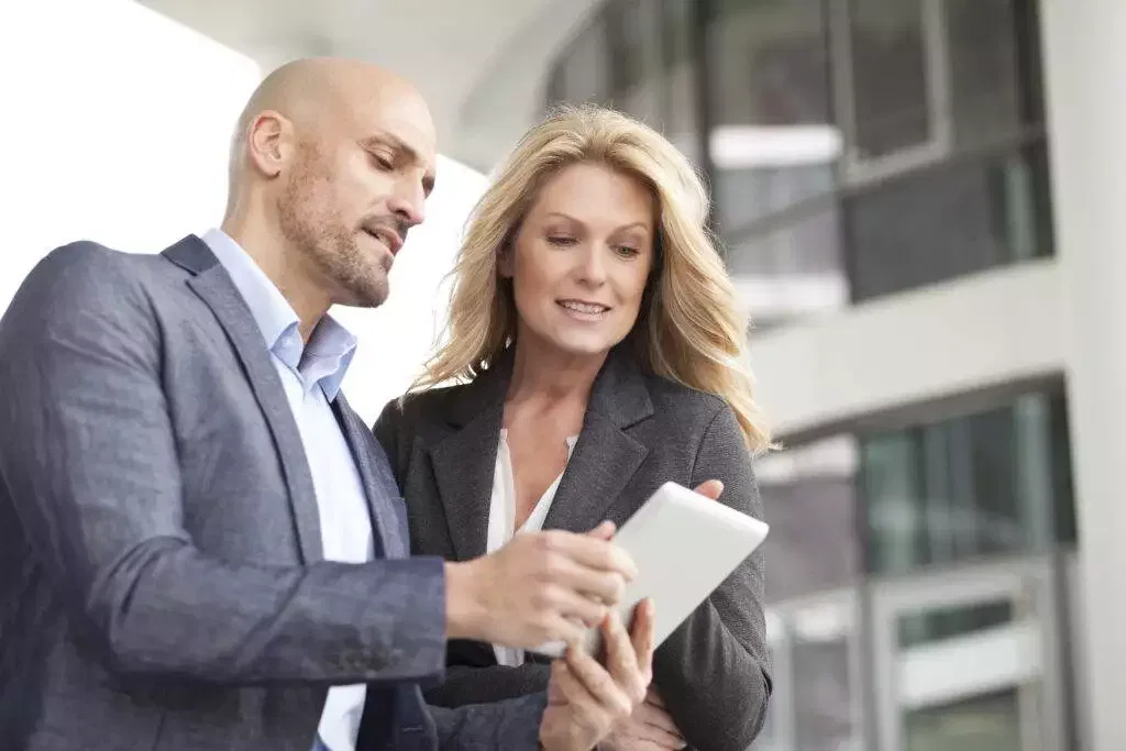 Two business professionals reviewing a tablet together.