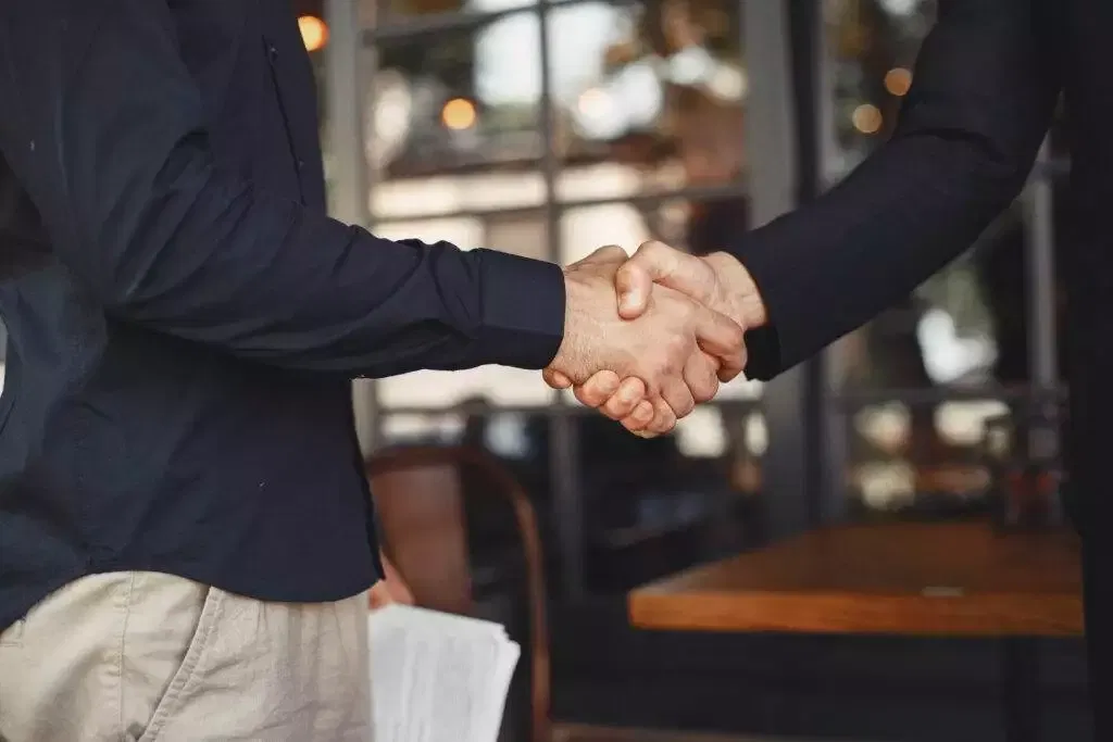 Two men shaking hands, signifying a business deal or partnership. Australian Financial Services Licence (AFSL) acquisition.