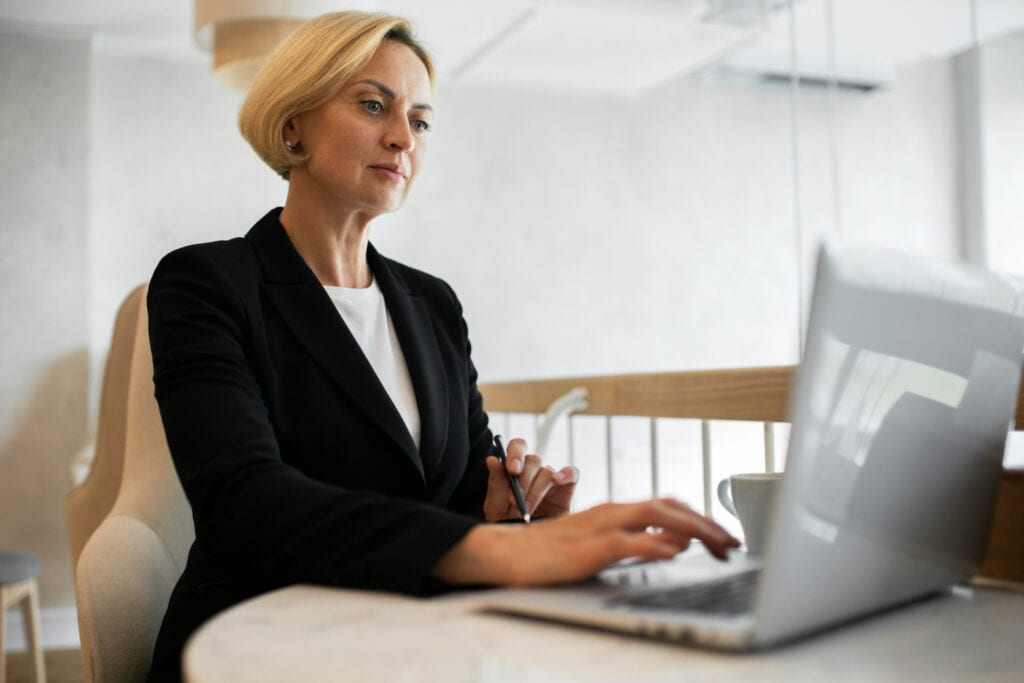 a woman sitting at a table using a laptop