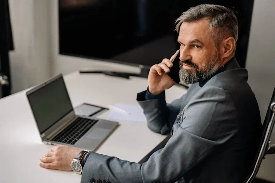 Businessman reviewing financial documents while on a phone call.