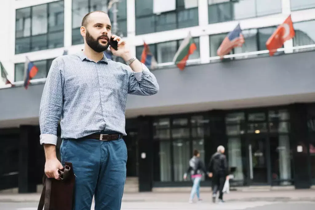Businessman on phone outside modern building