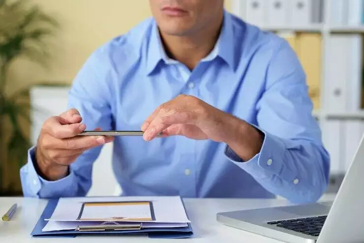 Businessman reviewing documents, preparing to cancel Australian Credit Licence.