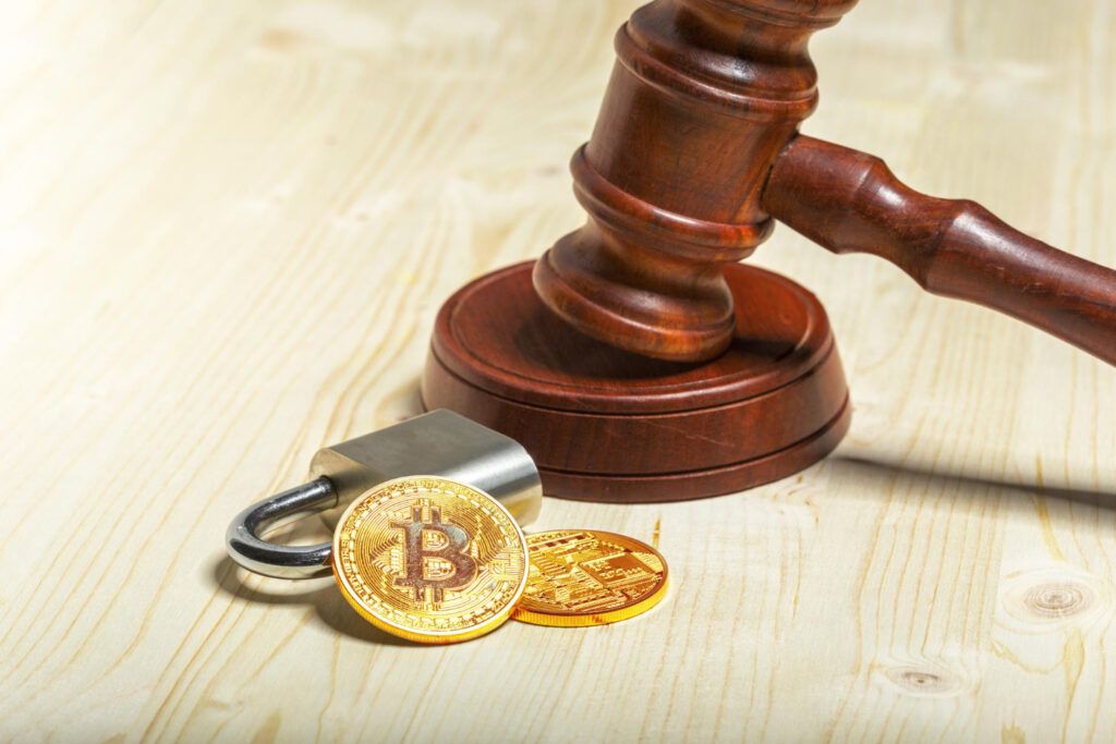 Gavel, padlock, and Bitcoin coins symbolizing legal issues in the crypto world.