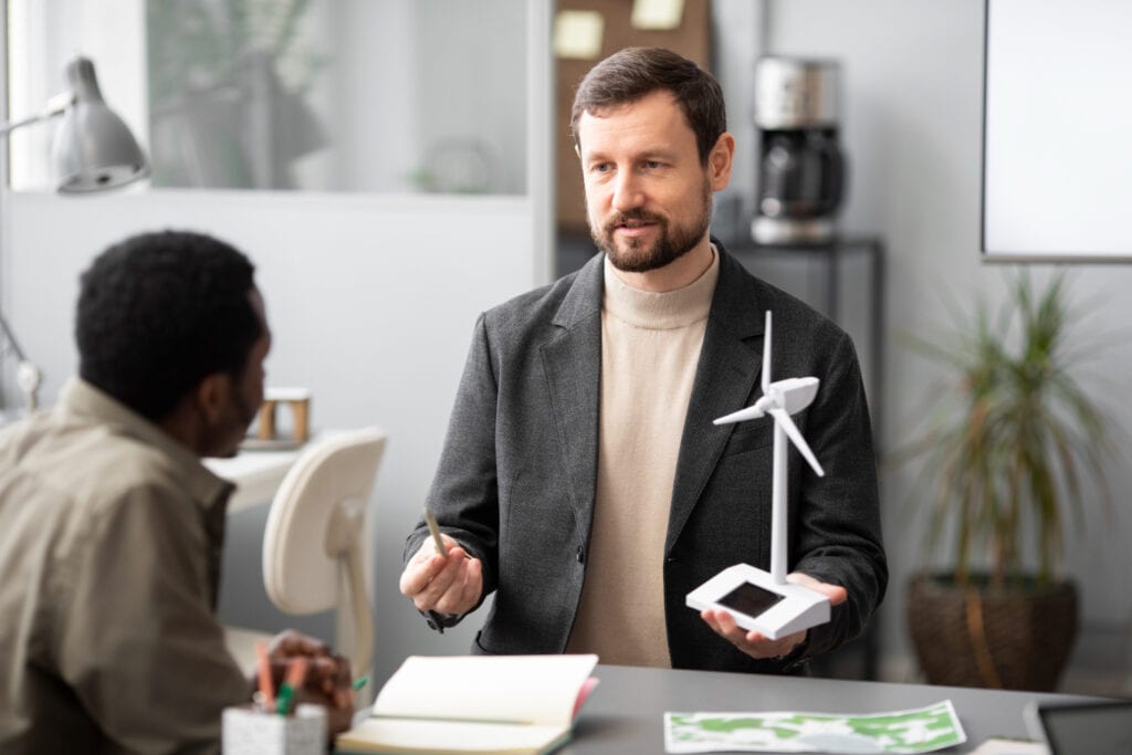 Businessmen discussing carbon credits with a wind turbine model on the desk, related to AFS Licence.