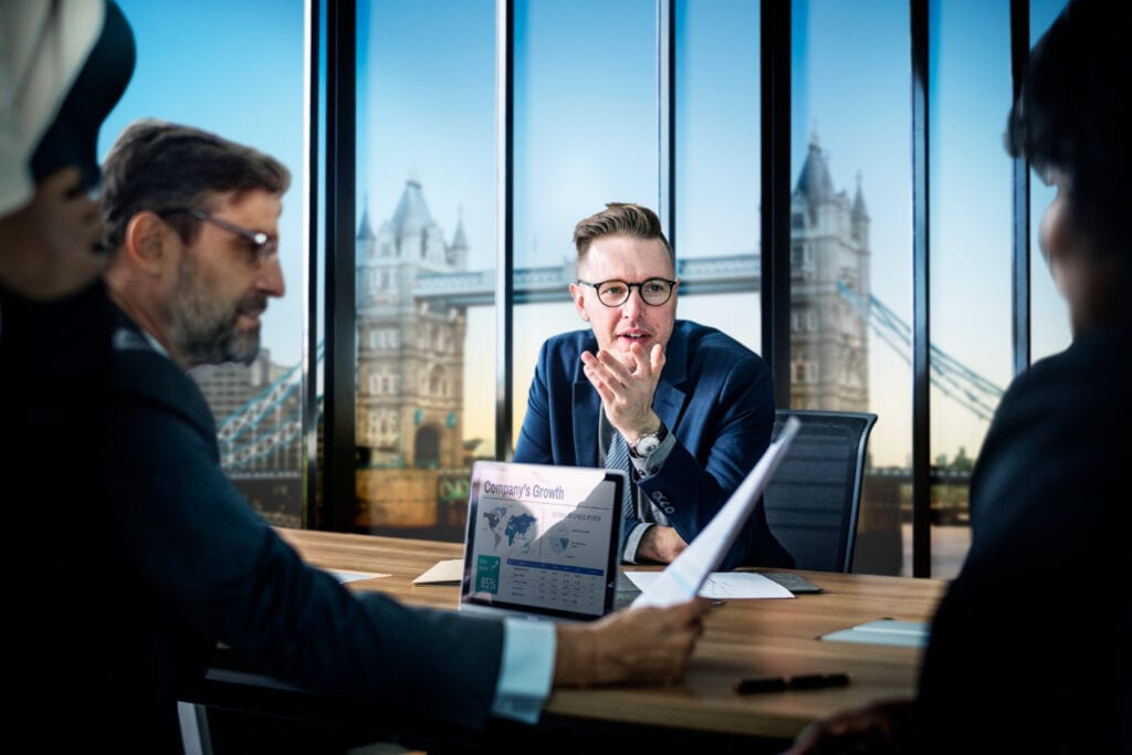 Australian share brokers discuss company growth chart in meeting.