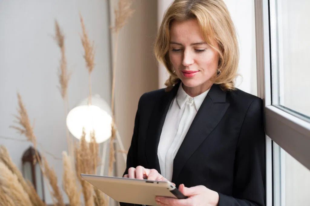 a woman in a suit holding a tablet
