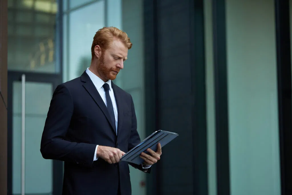 a man in a suit and tie looking at a tablet