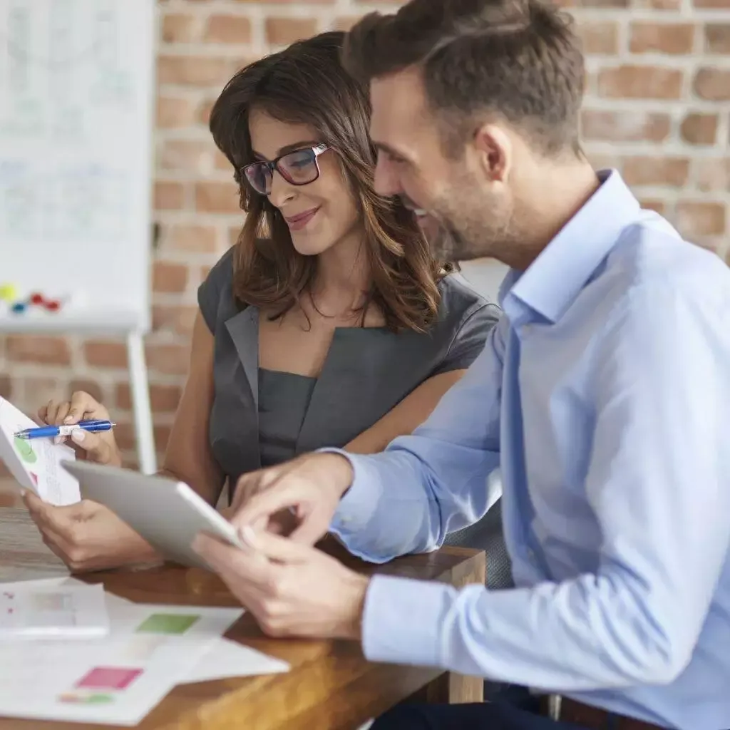 Business colleagues reviewing documents and using a tablet.