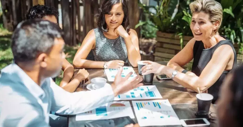 Business professionals collaborating around a table, reviewing financial documents. Australian financial services license (AFSL) compliance.