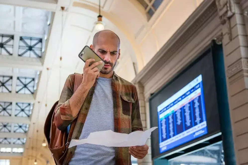 Man on phone reviewing map, considering Australian financial license options.