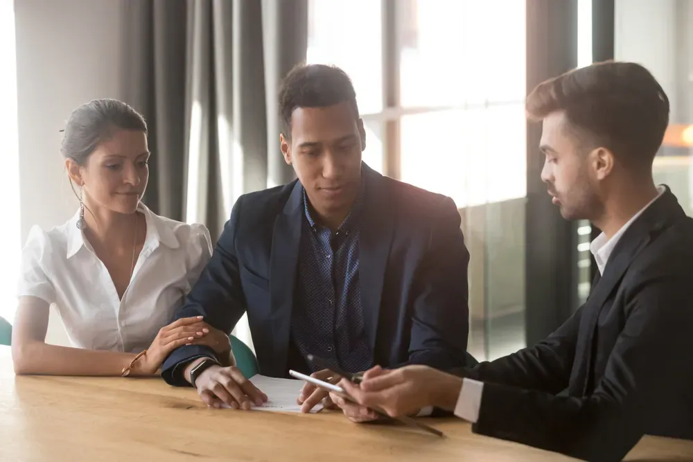 Business professionals reviewing documents, discussing legal or financial matters.