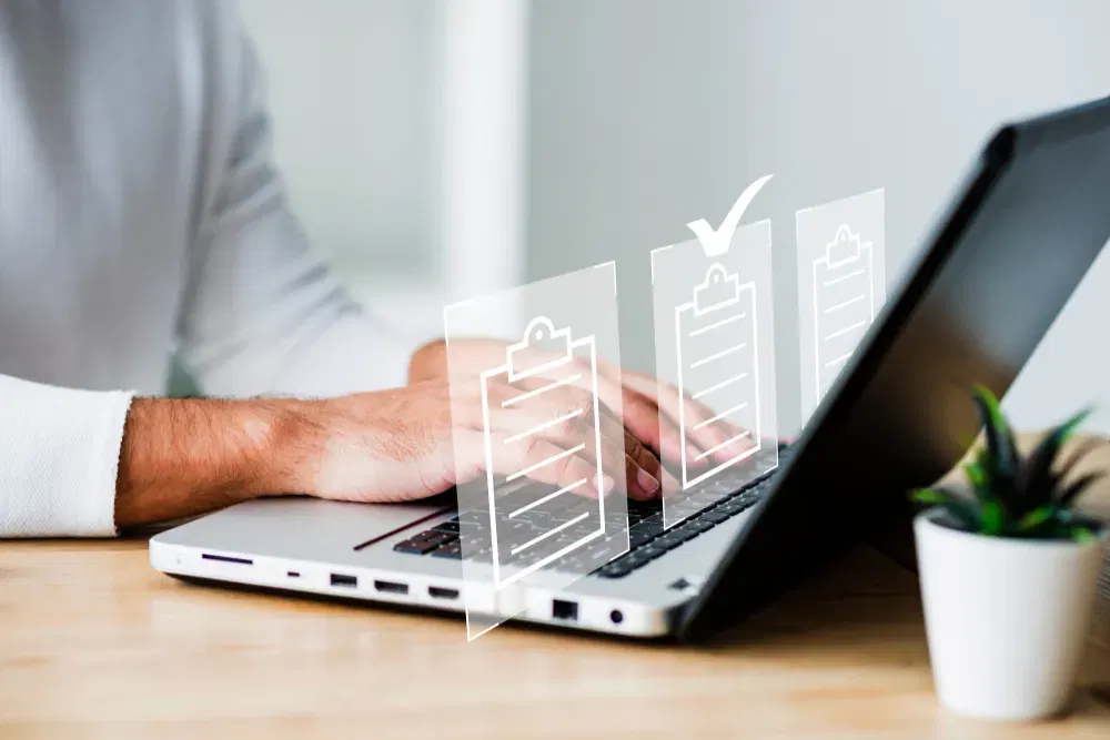 Person using laptop, checklist icons indicating task completion. AFSL compliance update.