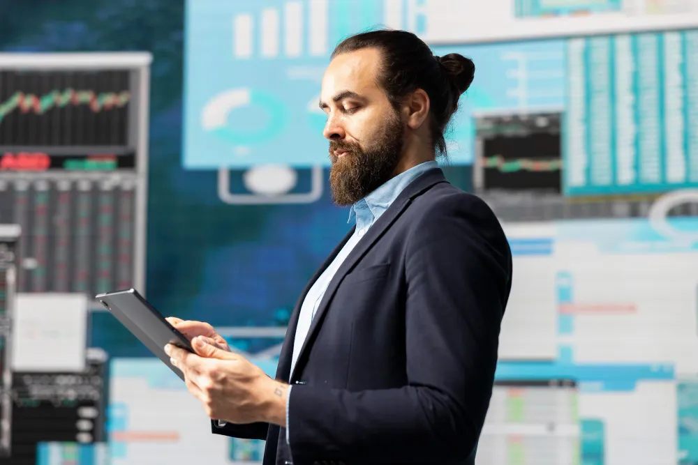 Man in suit analyzing data on a tablet, surrounded by crypto market charts. Digital asset analysis.